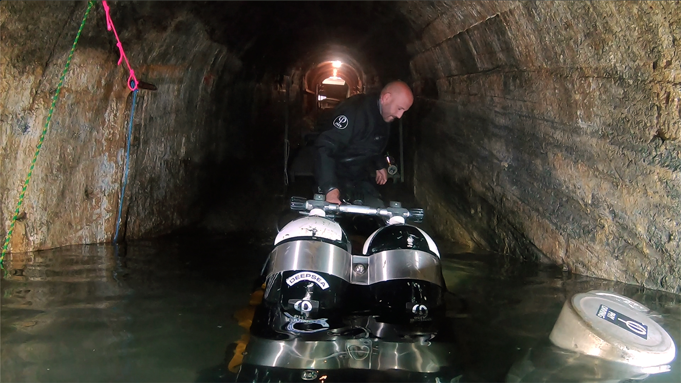 Team member brings dive equipment into Felicitus Mine for the dive expedition.