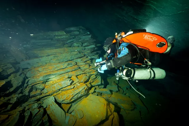 Diver sheds light on slabs of slate inside the mine.