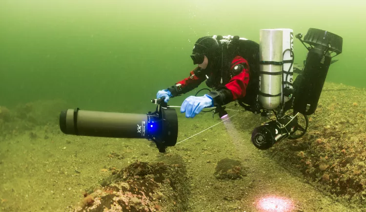 Support diver picking up stages and scooters during a shallow decompression stop