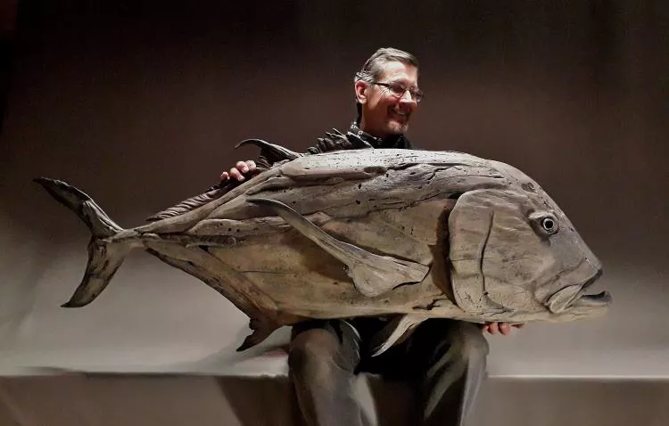 The artist, Tony Fredriksson, with his driftwood sculpture Giant Trevally