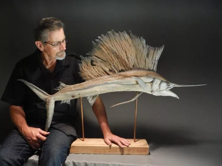 The artist, Tony Fredriksson, with his driftwood sculpture Sailfish
