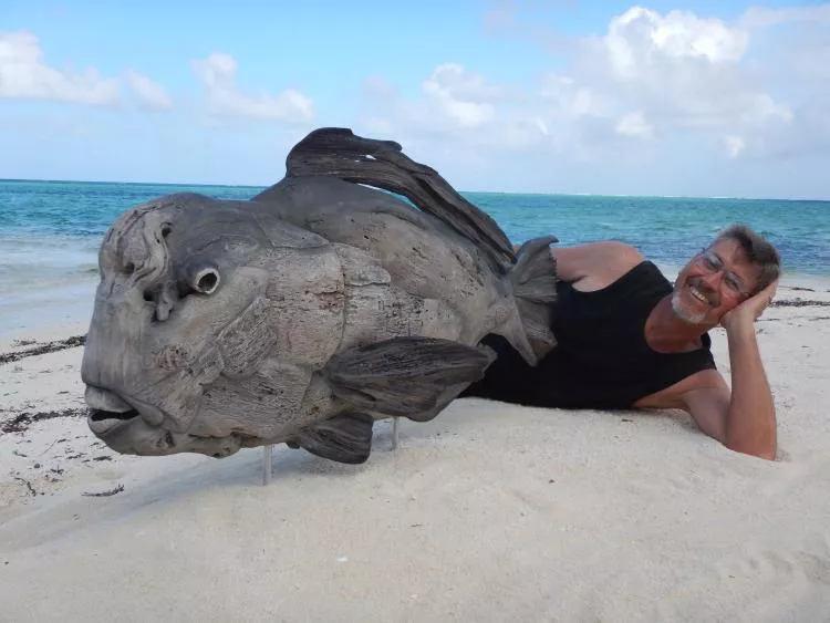 The artist, Tony Fredriksson, with his driftwood sculpture Bumphead Parrotfish