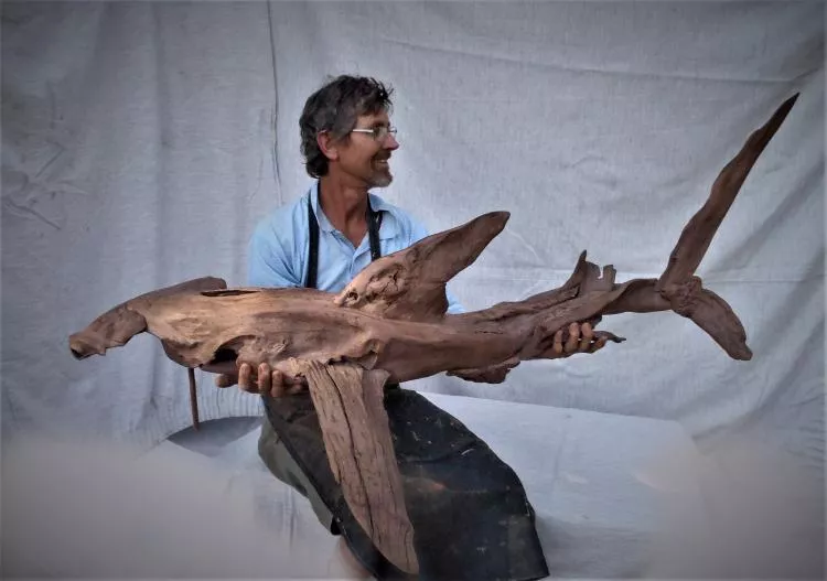 The artist, Tony Fredriksson, with his driftwood sculpture Hammerhead Shark