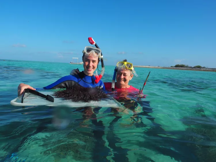 Researchers Dione Decker (left) and Professor Maria Byrne, with an adult crown-of-thorns starfish at the Great Barrier Reef.